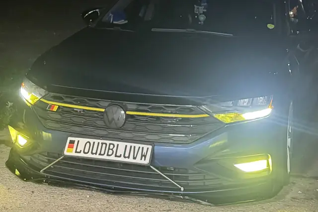 Volkswagen at night showing a yellow accent line across the headlight and grille trim