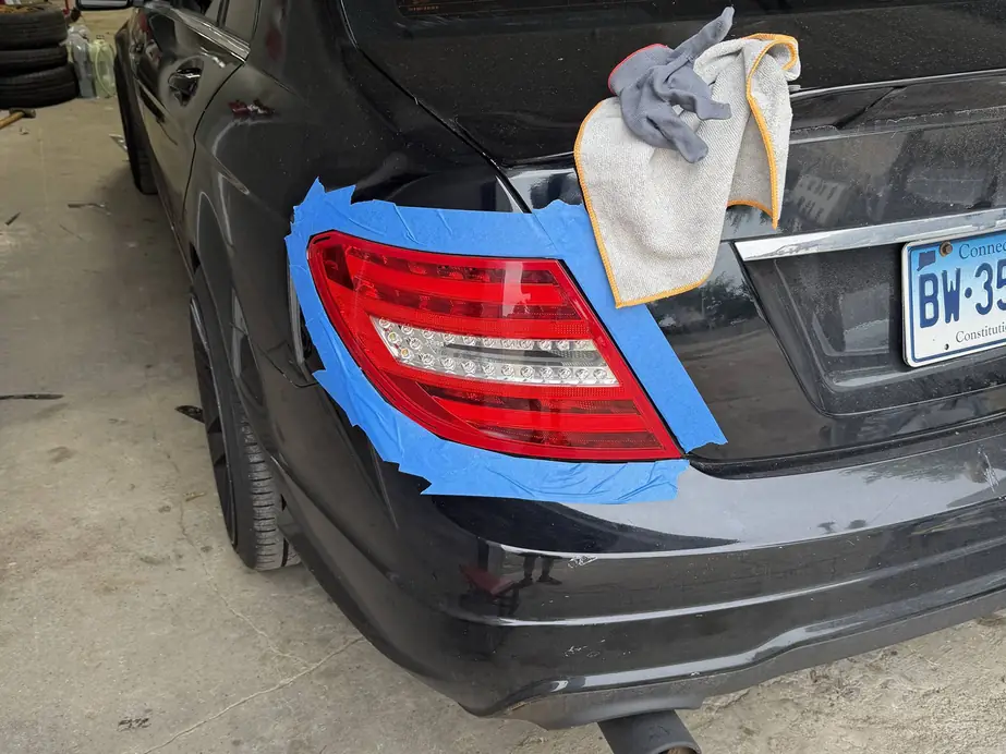 Mercedes C-class tail light masked and prepped for tinting inside the Rook Auto Customs shop