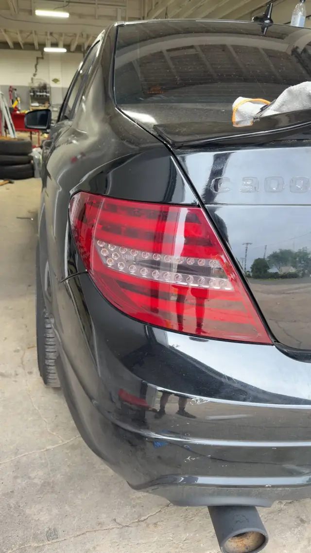 Close detail of a Mercedes C300 tail light being tinted on the bench at Rook Auto Customs