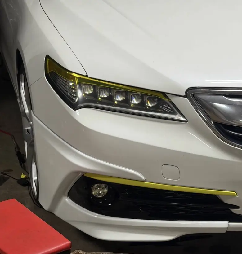 Finished headlight wrap in yellow tint with a matching fog light accent on an Acura
